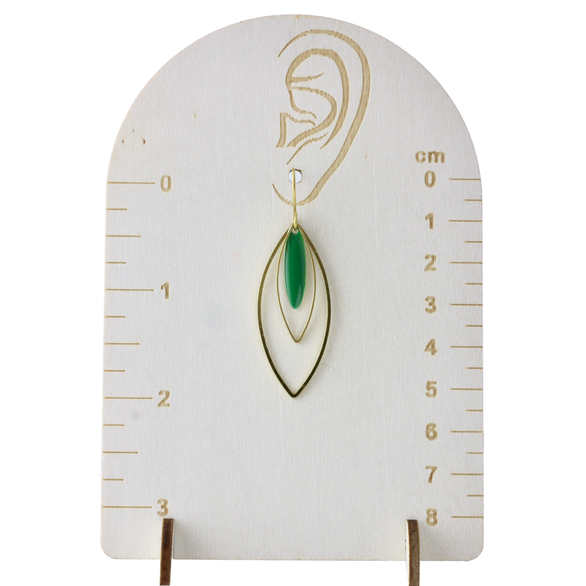 a pair of green earrings on a ruler